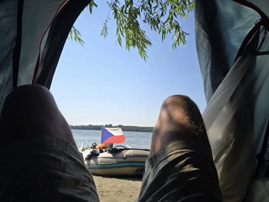 Tábor u řeky s českou vlajkou během výpravy