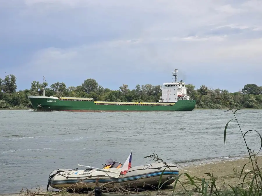 Nákladní loď na Dunaji vedle raftu